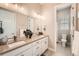 Bathroom with dual sinks, large mirror, and view of adjacent shower at 2134 S Poppy St, Lakewood, CO 80228