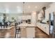 Bright kitchen featuring stainless steel appliances, a center island, and a breakfast bar with seating at 2134 S Poppy St, Lakewood, CO 80228