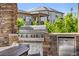 Outdoor kitchen featuring a built-in gas grill and stainless steel refrigerator at 2134 S Poppy St, Lakewood, CO 80228