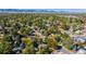Expansive aerial view showcasing the residential neighborhood with lush trees and distant mountain views at 5898 Parfet Ct, Arvada, CO 80004