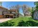 Landscaped backyard with mature trees, a raised deck, and a glimpse of the house at 5898 Parfet Ct, Arvada, CO 80004
