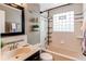 Updated bathroom with a tub, a glass block window, and decorative tile at 5898 Parfet Ct, Arvada, CO 80004