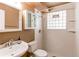 Bathroom featuring glass block window and tiled shower at 5898 Parfet Ct, Arvada, CO 80004