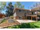 Exterior shot of the home showing a well-maintained yard, a raised deck, and brick accents at 5898 Parfet Ct, Arvada, CO 80004