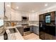 Modern kitchen featuring stainless steel appliances, stylish tile backsplash, and sleek countertops at 5898 Parfet Ct, Arvada, CO 80004