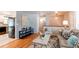 Open-concept living area featuring hardwood floors, a stylish sofa, and modern decor at 5898 Parfet Ct, Arvada, CO 80004