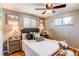 A cozy bedroom featuring a ceiling fan, hardwood floors, and coordinated decor at 5898 Parfet Ct, Arvada, CO 80004
