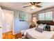 A cozy bedroom featuring a ceiling fan, hardwood floors, and coordinated decor at 5898 Parfet Ct, Arvada, CO 80004