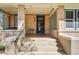 Inviting front porch featuring brick columns, concrete stairs, and a glass block window accent at 1176 Gaylord St # 101, Denver, CO 80206