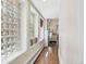 Hallway with hardwood floors, wall of glass block windows and views into other living spaces at 1176 Gaylord St # 101, Denver, CO 80206