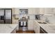 Modern kitchen with white cabinets, stainless steel appliances, and marble countertops at 1176 Gaylord St # 101, Denver, CO 80206