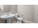 A minimalist half bathroom with a pedestal sink and modern fixtures offers simple functionality at 17311 Rose Mallow St, Parker, CO 80134
