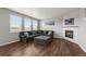 Comfortable living room featuring an oversized sofa, modern fireplace, and warm hardwood floors at 17311 Rose Mallow St, Parker, CO 80134