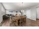 Open-concept space featuring a dining table, comfortable seating, fireplace and warm wood floors at 17311 Rose Mallow St, Parker, CO 80134