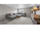 Comfortable living room featuring a large gray sectional sofa and ottoman, perfect for relaxing at 17311 Rose Mallow St, Parker, CO 80134