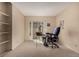 Neutral carpeted bedroom featuring shelving, a slider door, and space for an office desk at 3657 S Laredo St # E, Aurora, CO 80013