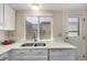Bright kitchen featuring white cabinets, stainless steel appliances, quartz countertops, and a garden window at 3657 S Laredo St # E, Aurora, CO 80013