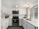 Bright kitchen featuring white cabinets, stainless steel appliances, quartz countertops, and a garden window at 3657 S Laredo St # E, Aurora, CO 80013