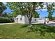 Spacious backyard with lush green grass, a mature tree, and a detached garage at 5525 Pierce Ct, Arvada, CO 80002