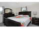 Comfortable bedroom with matching dark furniture, a floral bedspread, and natural light from the window at 5525 Pierce Ct, Arvada, CO 80002