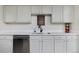 Stylish kitchen featuring bright countertops, white cabinets, and stainless steel dishwasher at 5525 Pierce Ct, Arvada, CO 80002