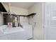 Bright laundry room with a washer, dryer, shelving, and a white door with a sheer curtain at 5525 Pierce Ct, Arvada, CO 80002