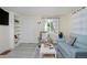 Bright living room with a built-in bookshelf, comfortable recliner, and a stylish blue sofa at 5525 Pierce Ct, Arvada, CO 80002