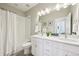 Neutral bathroom with double sinks, white cabinets, and a shower-tub combo with white shower curtain at 15993 E 112 Pl, Commerce City, CO 80022