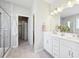 Bright bathroom features double sinks, white cabinets, stone tile flooring, and a glass-enclosed shower at 15993 E 112 Pl, Commerce City, CO 80022