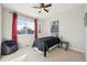 Bright bedroom featuring a ceiling fan, neutral walls and carpet, and a large window providing natural light at 15993 E 112 Pl, Commerce City, CO 80022