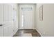 Bright foyer with white door, dark wood floors, stylish trim, and contemporary decor at 15993 E 112 Pl, Commerce City, CO 80022