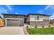 Modern, single-story home with stone and siding details, a two-car garage, professional landscaping, and a well-manicured lawn at 15993 E 112 Pl, Commerce City, CO 80022