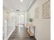 Hallway featuring wood floors, white railing, decor, and a view to the front door at 15993 E 112 Pl, Commerce City, CO 80022