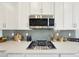 Kitchen countertop with gas range, modern appliances, and stylish backsplash at 15993 E 112 Pl, Commerce City, CO 80022