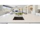 Large kitchen island with sink, seating, and view of the living room at 15993 E 112 Pl, Commerce City, CO 80022