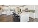 Open kitchen with white cabinets, large island with seating, and modern appliances at 15993 E 112 Pl, Commerce City, CO 80022