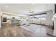 Bright, open-concept living room and kitchen area with hardwood floors, neutral colors, and a large window for plenty of light at 15993 E 112 Pl, Commerce City, CO 80022