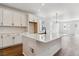 Open kitchen with white cabinetry, subway tile backsplash, and a quartz countertop island with a black gooseneck faucet at 24778 E 40Th Ave, Aurora, CO 80019