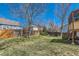 Large backyard with mature trees, green lawn, and a wooden privacy fence at 11437 W 103Rd Ave, Broomfield, CO 80021