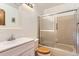 Small full bathroom with a white sink and cabinet, tub, and sliding shower door at 11437 W 103Rd Ave, Broomfield, CO 80021