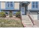 Inviting home entry with a covered porch and charming landscaping, including a brick retaining wall at 11437 W 103Rd Ave, Broomfield, CO 80021