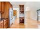 Open kitchen space features a stainless steel refrigerator, wooden cabinets, and access to multiple rooms at 11437 W 103Rd Ave, Broomfield, CO 80021