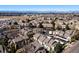 Aerial view of a residential community featuring townhouses, parking, green spaces, and mountain views in the distance at 1885 S Quebec Way # J106, Denver, CO 80231