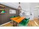 Stylish dining room with wooden table, modern lighting, and green chairs, adjacent to kitchen at 1885 S Quebec Way # J106, Denver, CO 80231