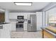 Bright kitchen with stainless steel appliances, white cabinets, and ample counter space at 1885 S Quebec Way # J106, Denver, CO 80231