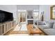 Bright living room with a fireplace, wood floors, modern furniture, and a sliding glass door to the outdoor deck at 1885 S Quebec Way # J106, Denver, CO 80231