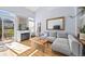 Sunny living room featuring a fireplace, sectional couch, wood floors, and sliding glass doors at 1885 S Quebec Way # J106, Denver, CO 80231