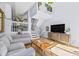 Open-concept living room featuring high ceilings, modern staircase, lots of plants, and wood floors at 1885 S Quebec Way # J106, Denver, CO 80231