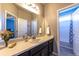 Well-lit bathroom featuring a single sink vanity, framed mirror and tub with decorative shower curtain at 26960 E Costilla Dr, Aurora, CO 80016