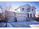 Charming two-story home with three-car garage, snow-covered driveway, and covered porch at 26960 E Costilla Dr, Aurora, CO 80016